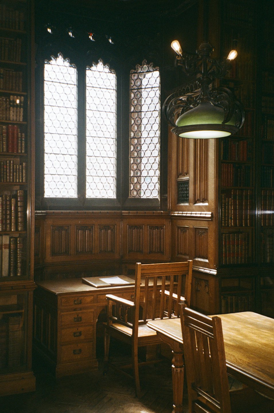 Bookshelves and wooden furniture fill a classic library room.